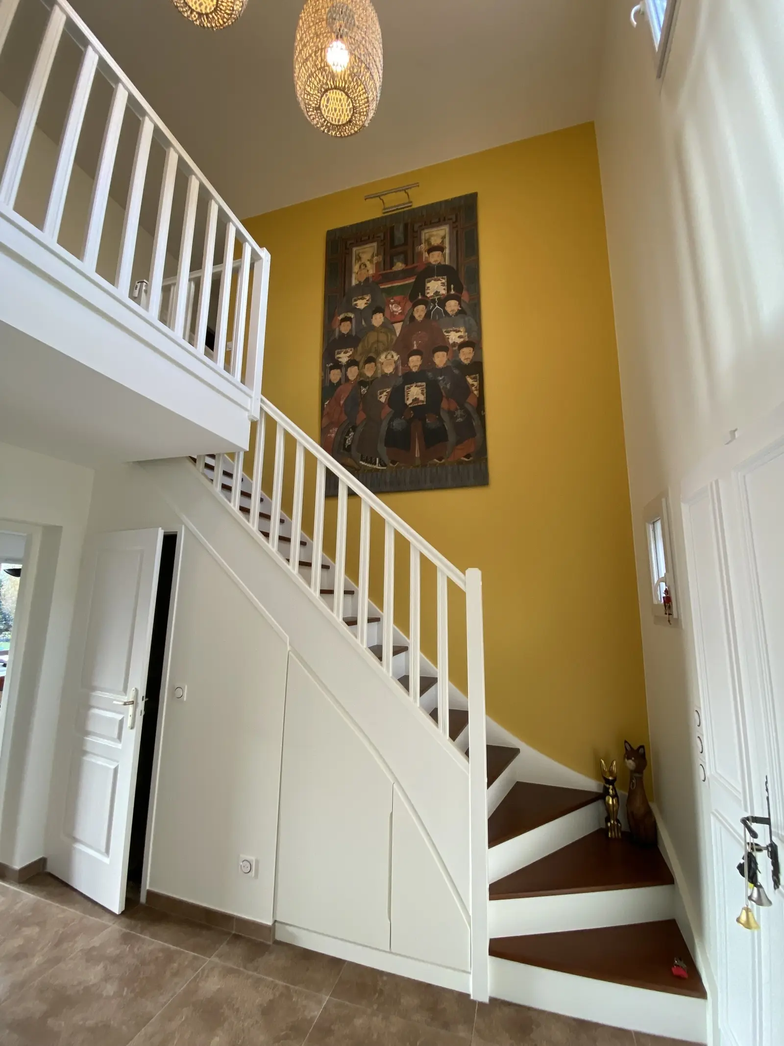 Escalier récemment rénové dans une maison lumineuse. Les marches en bois foncé contrastent élégamment avec les contremarches blanches immaculées et la rampe, créant un aspect moderne et soigné.