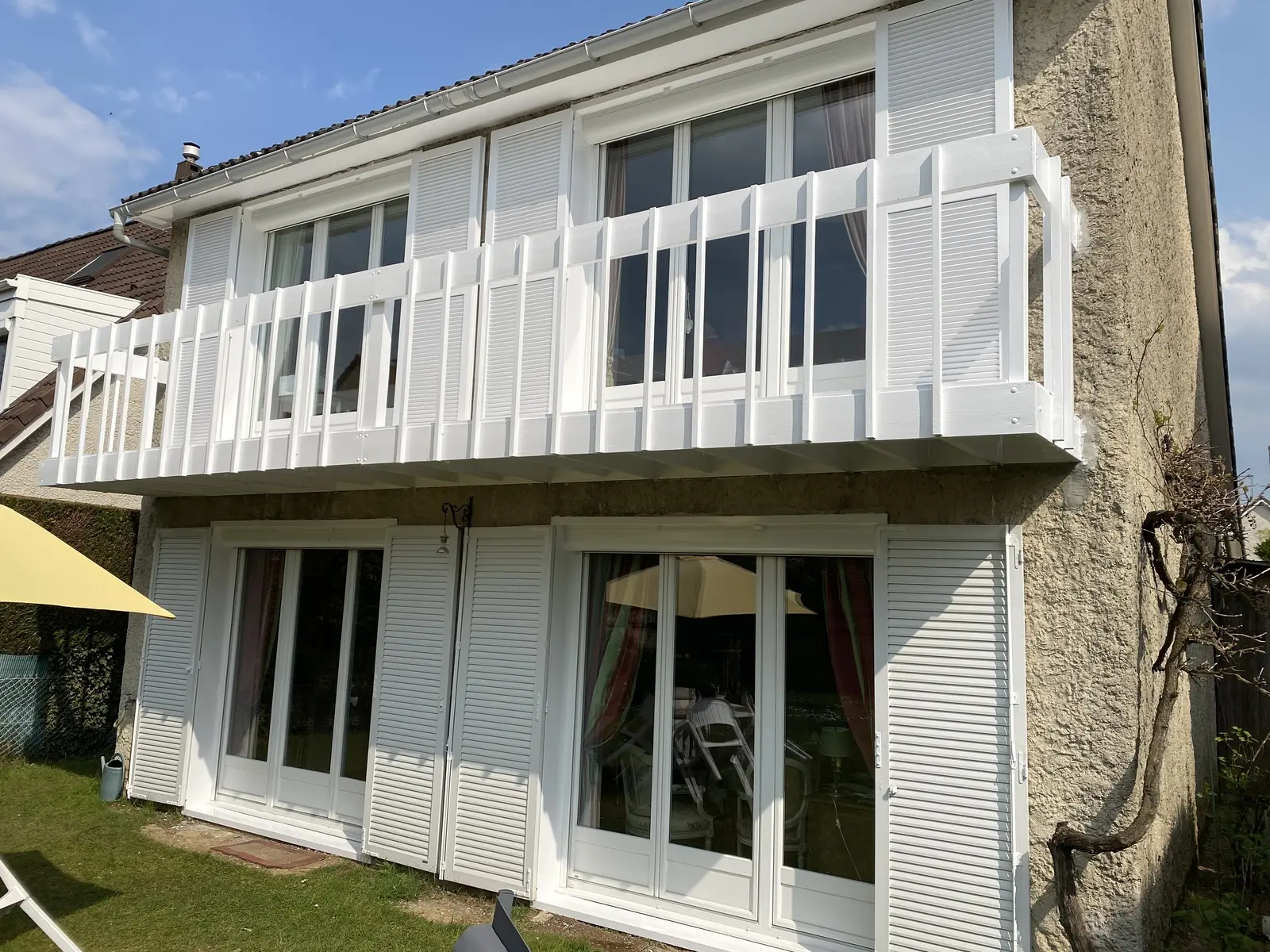 Balustrades et volets fraîchement repeints en blanc, offrant un aspect propre, soigné et impeccable.